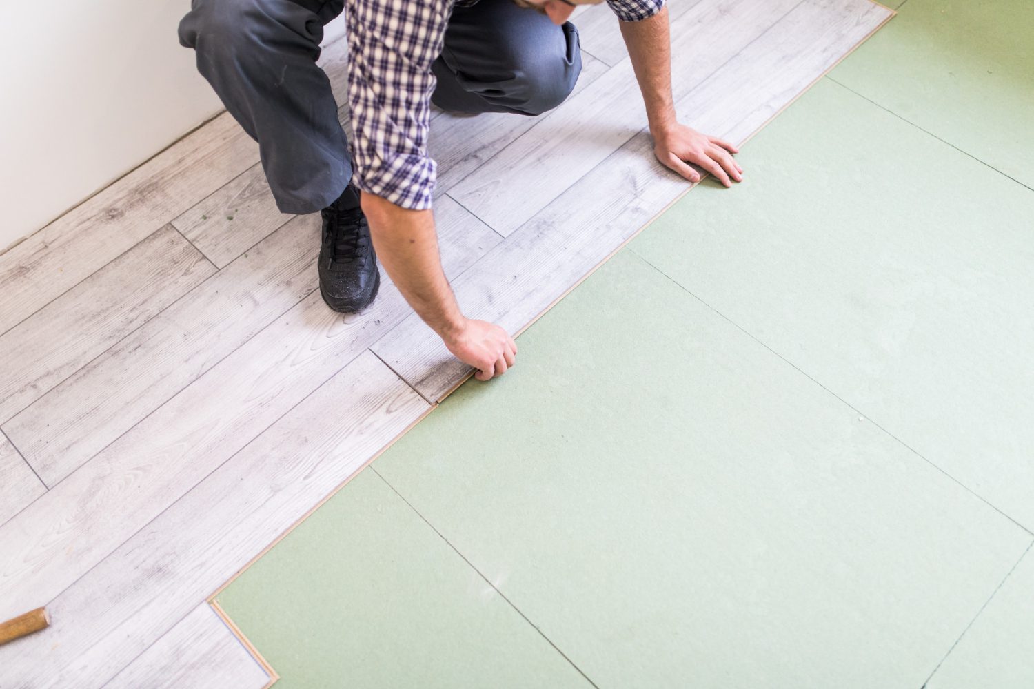worker-processing-floor-with-bright-laminated-flooring-boards